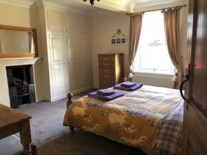 约克Ceilidh Cottage的一间卧室配有一张带紫色毛巾的床