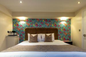 伦敦Hotel Shepherds Bush London的一间卧室配有一张带花卉壁纸的大床