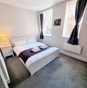 伯恩茅斯Modern Maisonette 2 Bedrooms Newly Renovated的卧室配有白色的床和2条毛巾