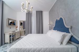 特罗佩阿The Gentleman of Tropea的卧室配有蓝色和白色的床和书桌。