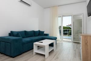萨索斯Diamanti Apartments Downtown Limenas Thasos的客厅配有蓝色的沙发和桌子