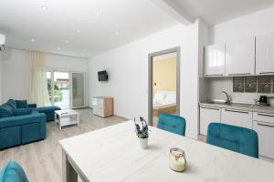 萨索斯Diamanti Apartments Downtown Limenas Thasos的厨房以及带桌子和蓝色椅子的客厅。