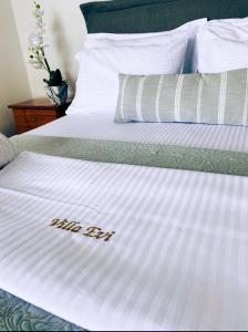 阿莫利亚尼岛Villa Evi的一张白色的床,上面写着丝绸辅助工具