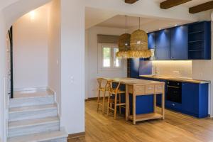 克里皮吉Dekalo Seaside Villa, Kriopigi的厨房配有蓝色橱柜和木桌