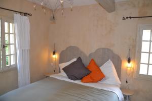 穆斯捷-圣玛丽莫斯提尔之家招待所的一间卧室配有带橙色和灰色枕头的床