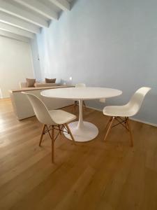 卡洛福泰Le Vele Carloforte的客房内的一张白色桌子和两把白色椅子