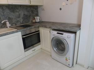 布尔加斯Apartament HOLIDAY的厨房配有洗衣机和水槽