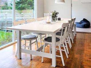 特雷勒堡5 person holiday home in TRELLEBORG的白色餐桌和白色椅子