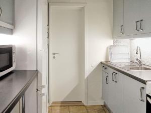 特雷勒堡5 person holiday home in TRELLEBORG的白色的厨房配有水槽和微波炉