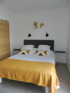 马莱莫尔L’ escapade的卧室配有白色的床,上面有黄色的毯子