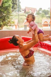 佩德拉阿祖尔法泽达中国花园酒店的把孩子放在水库中的女人