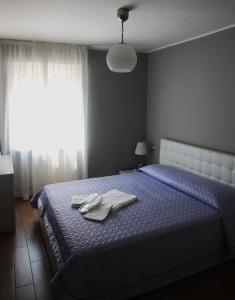 Borghetto LodigianoCasa Jomi b&b Borghetto Lodigiano的一间卧室配有蓝色的床和毛巾