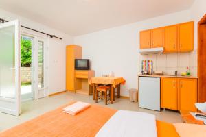 蒂瓦特Rosić Apartments的一间带一张床的房间和一间带桌子的厨房