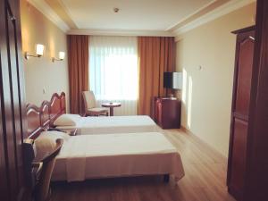伊斯坦布尔Grand Hotel Seferoğlu的酒店客房设有两张床和窗户。