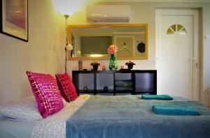KétegyházaKultúrÉlet Vendégháza的一间卧室配有带粉红色和蓝色枕头的床