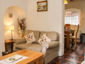 特尔福德Bridge View Cottage的客厅配有沙发和桌子