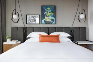 沃思堡Kimpton - Harper Hotel, an IHG Hotel的卧室配有一张带橙色枕头的大型白色床。