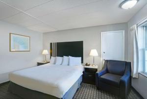 华盛顿Motel 6 Washington, PA的配有一张床和一把椅子的酒店客房
