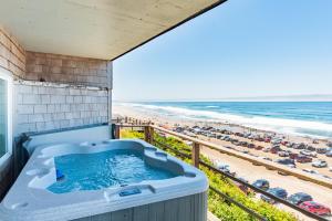 林肯市Seagull Beachfront Inn的俯瞰海滩的阳台上的热水浴池
