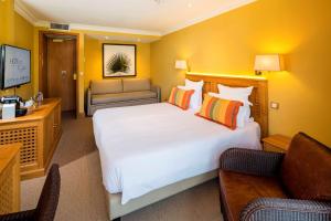 圣马克西姆Best Western Premier Montfleuri的酒店客房设有一张大床和一张沙发。