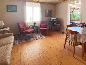 韦特兰达4 person holiday home in VETLANDA的客厅配有椅子、桌子和电视
