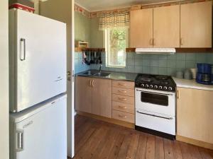 韦特兰达4 person holiday home in VETLANDA的厨房配有白色冰箱和炉灶。