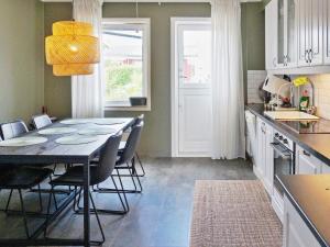 Hallstavik5 person holiday home in HALLSTAVIK的厨房里设有1间带桌椅的用餐室