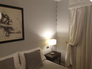 维戈Apartamento Velázquez Moreno的一间带沙发、灯和窗户的卧室