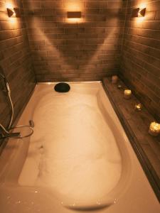 戈里察Hotel Romeo的带淋浴的浴室设有大浴缸