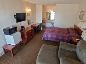 格伦代夫河畔汽车旅馆的酒店客房设有沙发、床和电视。