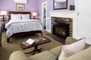 肯尼邦克港1802 House Bed & Breakfast的一间卧室配有一张床和一个壁炉