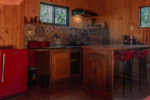 伊瓜苏港Cabaña Oma的厨房配有木制橱柜和红色冰箱。