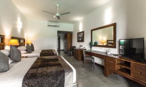 阿努拉德普勒Earls Rajarata的酒店的客房 - 带1张床、1台电视、1张床和1张书桌