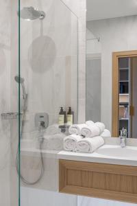 维尔纽斯CALVARY Hotel & Restaurant Vilnius的带淋浴和毛巾水槽的浴室