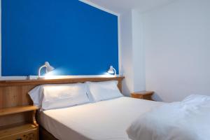 布勒伊-切尔维尼亚缪博卓利酒店的卧室配有白色的床和蓝色的墙壁