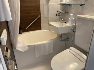 东京Ai Hotel Keikyu Kamata-ekimae的浴室配有卫生间、盥洗盆和浴缸。