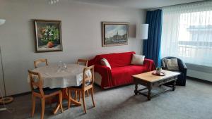 达沃斯Holiday accommodation - swimming pool available的客厅配有红色的沙发和桌子