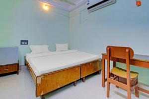 卡基纳达Decent residency的一间卧室配有一张床、一张桌子和一把椅子