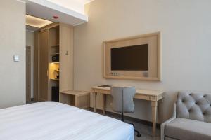 维尔纽斯CALVARY Hotel & Restaurant Vilnius的酒店客房配有一张床、一张书桌和一台电视。