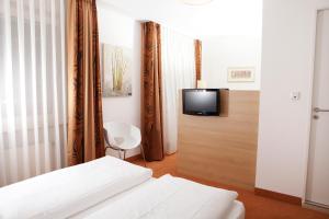 科隆弗朗德舍尔霍夫酒店的一间卧室配有一张床,墙上配有电视