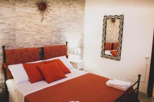 巴勒莫DAI MORI的一间卧室配有一张带红色枕头和镜子的床