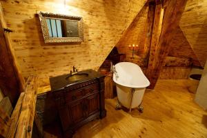 Počátky勒托拉德沃特科酒店的小屋内的浴室设有水槽和浴缸