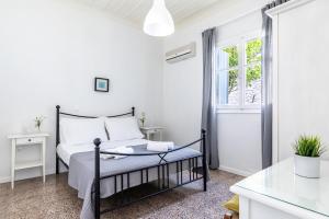帕诺尔莫斯斯科派洛斯PSARIANOS BEACHFRONT APARTMENTS的白色的卧室设有床和窗户