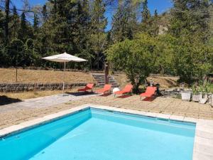 LʼEscarèneAppartement de 3 chambres avec piscine partagee jardin amenage et wifi a Berre les Alpes的一个带两把椅子和遮阳伞的游泳池