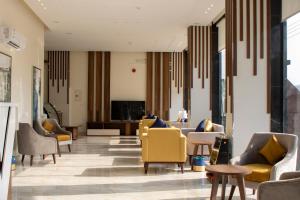 艾卜哈The Palace Hotel Suites - Al Badea的一间设有黄色椅子和桌子的等候室