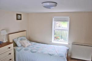 格伦贝赫Glenbeigh Holiday Cottage - Tigin Mamo的一间小卧室,配有床和窗户