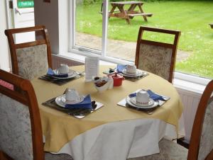 霍舍姆维布雷湖斯特住宿加早餐旅馆的一张桌子,上面有黄色的桌布,盘子和椅子