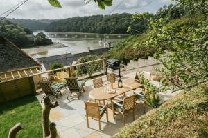 Saint ClementFinest Retreats - Tideway的庭院配有桌椅,俯瞰着河流