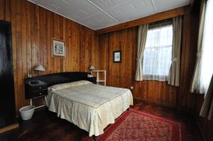 内罗毕奥克伍德酒店 的一间卧室设有床、窗户和木墙
