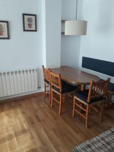 塞尔勒Agradable apartamento con jardín privado en Cerler的一间带木桌和椅子的用餐室